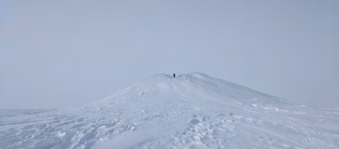 Photo showing Percy pingo, the tallest pingo that we will survey in the 2021 season, with a human at the summit for scale.
